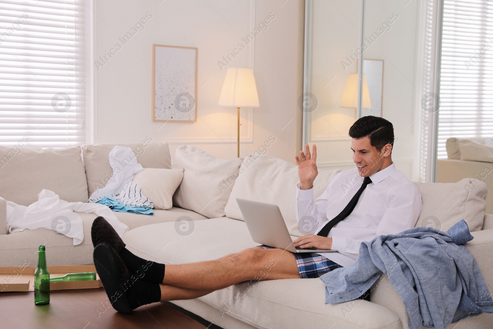 Photo of Man working on laptop in messy room. Stay at home concept