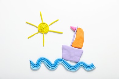 Photo of Colorful sun, boat and sea waves made from plasticine on white background, top view