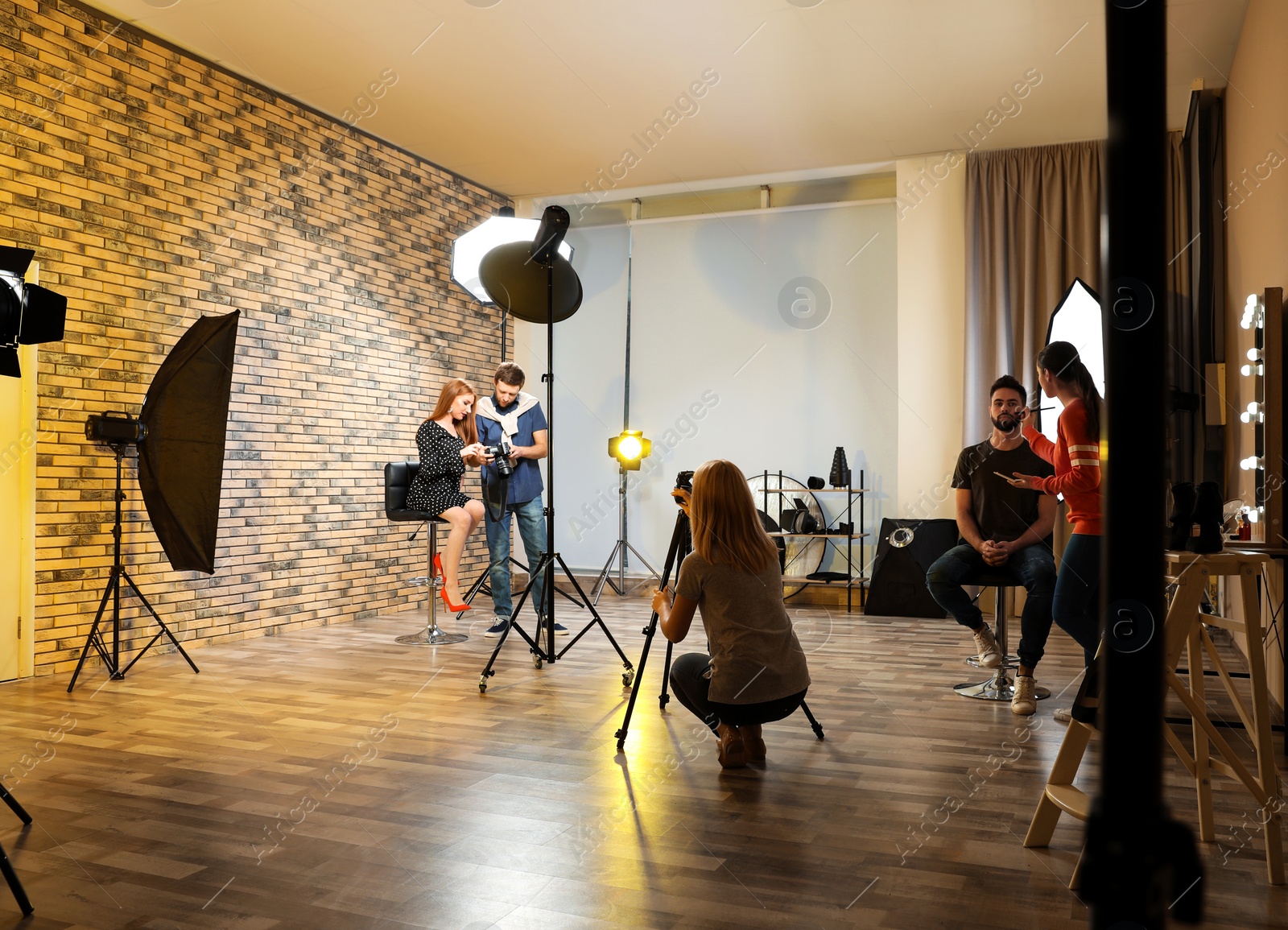 Photo of Photo studio with professional equipment and team of workers