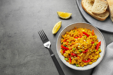 Photo of Delicious rice pilaf with vegetables on grey table, flat lay. Space for text
