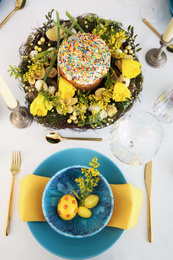 Photo of Festive Easter table setting with beautiful floral decor and eggs, above view