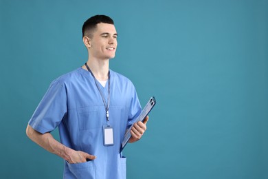 Photo of Portrait of smiling medical assistant with clipboard on light blue background. Space for text