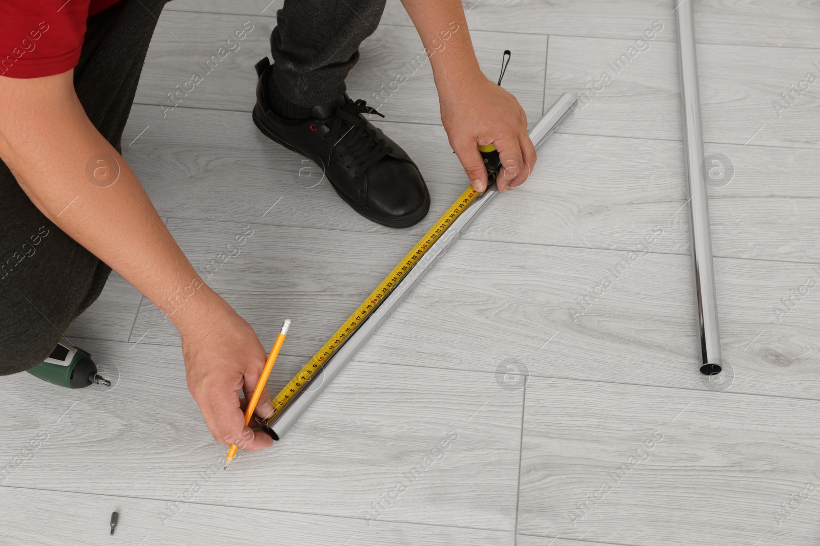 Photo of Worker measuring metal pipes for installation, closeup