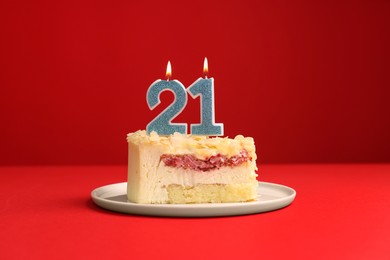 Coming of age party - 21st birthday. Delicious cake with number shaped candles on red background