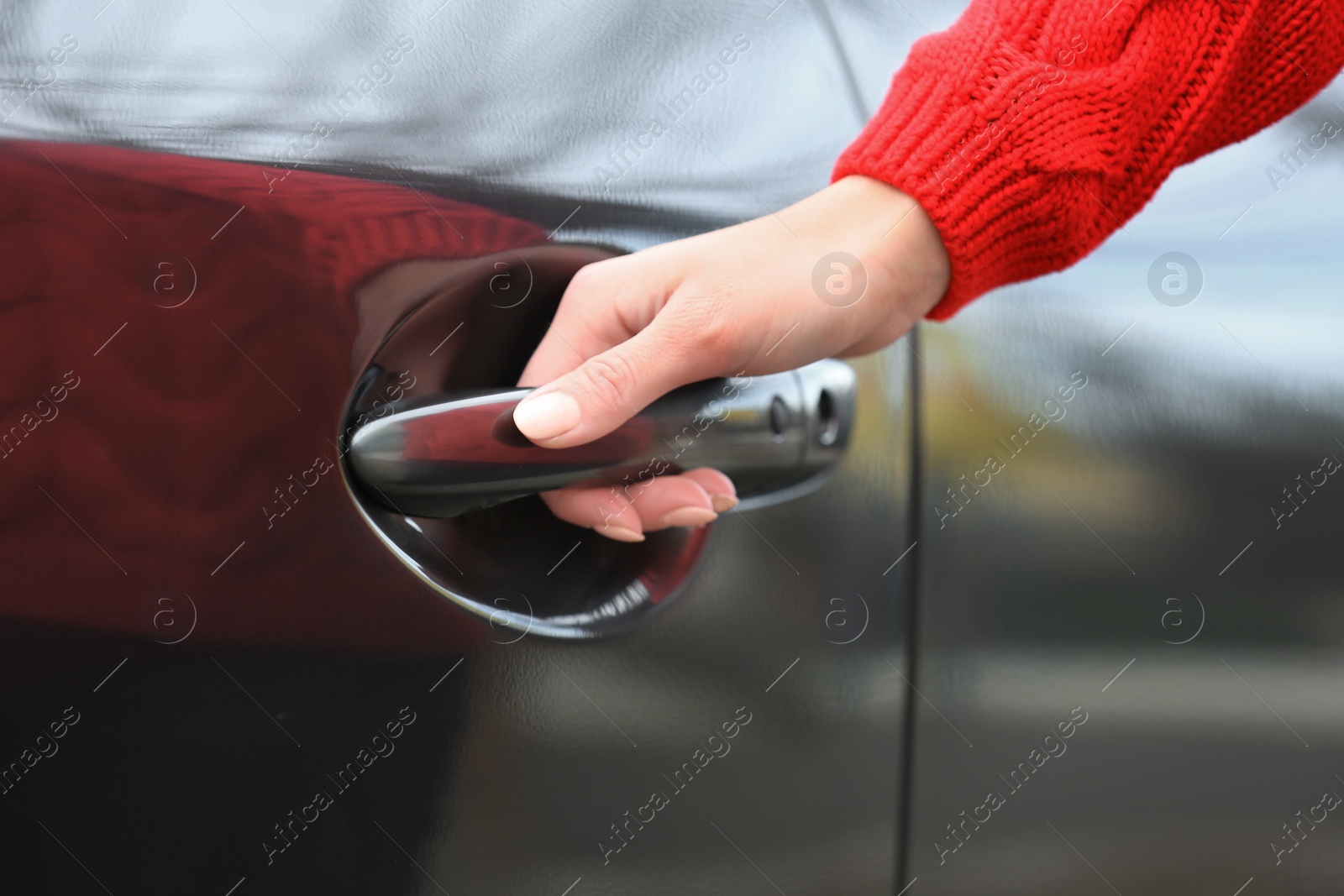 Photo of Closeup view of woman opening car door