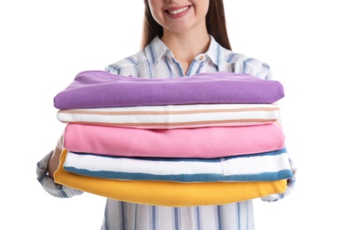 Photo of Young woman holding clean towels on white background, closeup. Laundry day