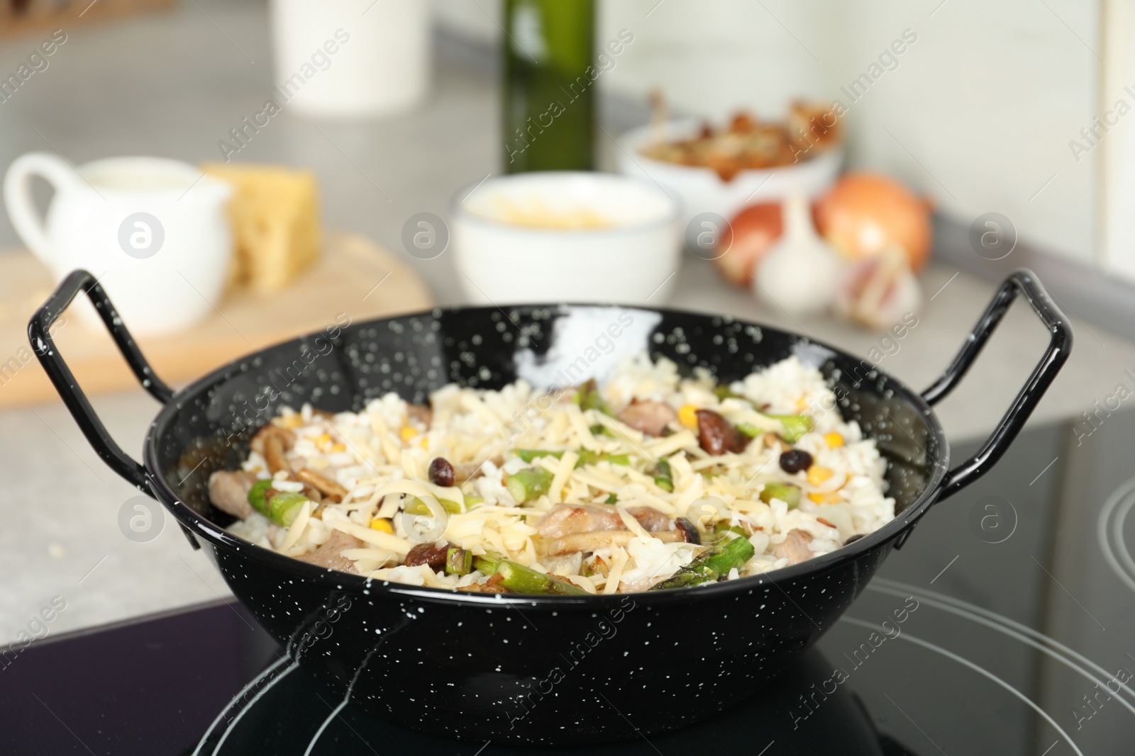 Photo of Delicious risotto in pan on induction stove