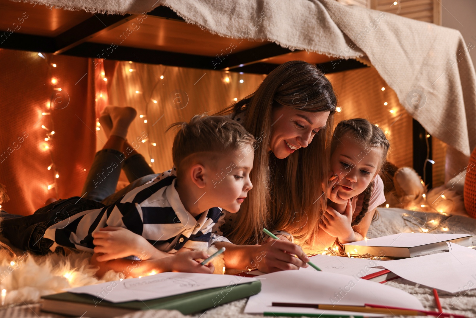 Photo of Mother and her children drawing in play tent at home