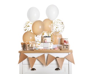Baby shower party. Different delicious treats on chest of drawers and decor against white background