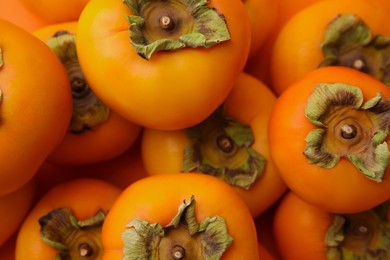Photo of Delicious ripe juicy persimmons as background, top view