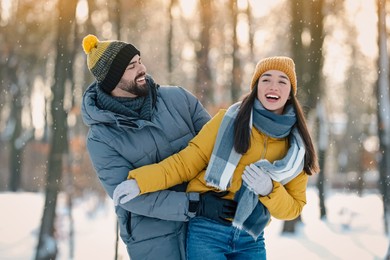 Happy young couple having fun outdoors on winter day