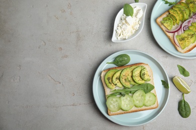 Photo of Flat lay composition with avocado toasts on grey table. Space for text