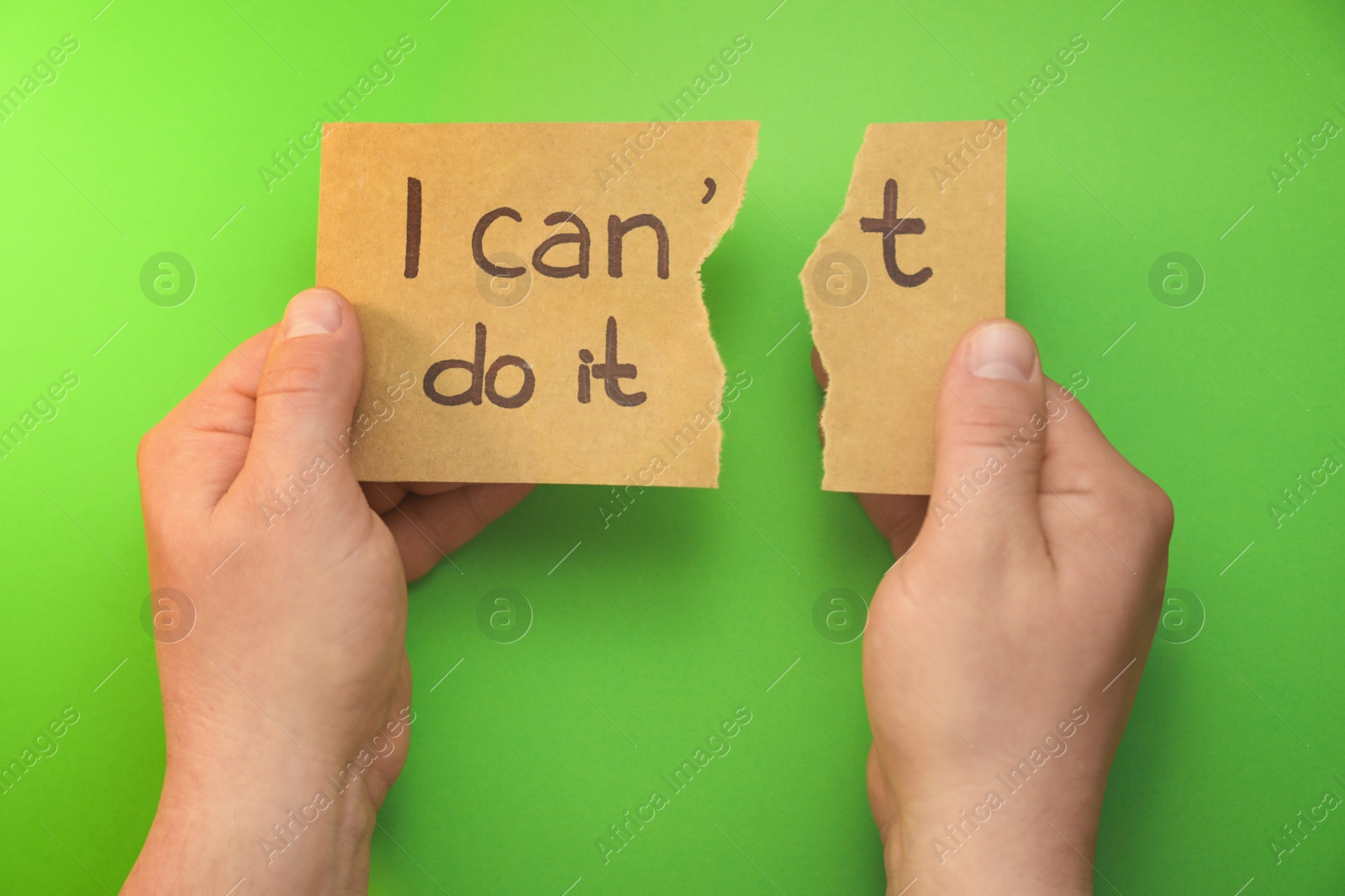 Photo of Man tearing card making phrase I Can Do It on green background, top view