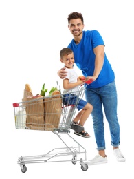 Father and son with full shopping cart on white background