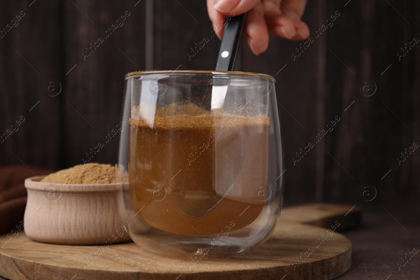Photo of Dietary fiber. Woman stirring psyllium husk powder in water at table, closeup