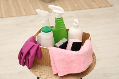 Photo of Different cleaning products in wooden box on table indoors