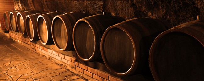 Image of Many wooden barrels in cellar, banner design