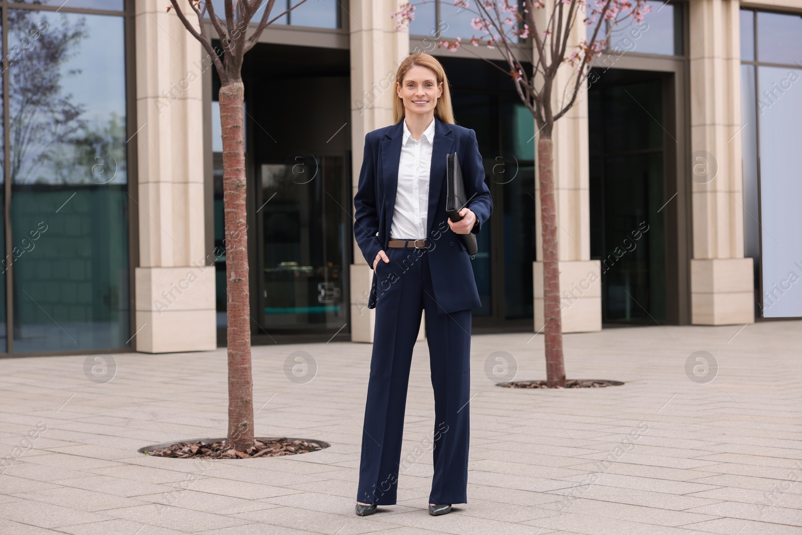 Photo of Female real estate agent with leather portfolio outdoors