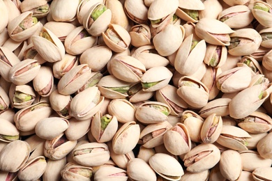 Photo of Organic pistachio nuts in shell as background, top view