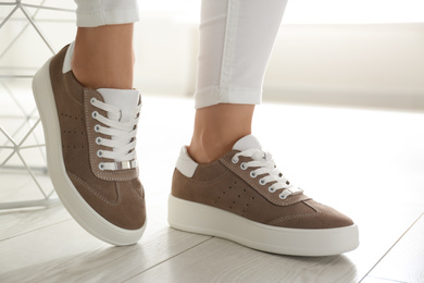 Photo of Woman wearing comfortable stylish shoes indoors, closeup