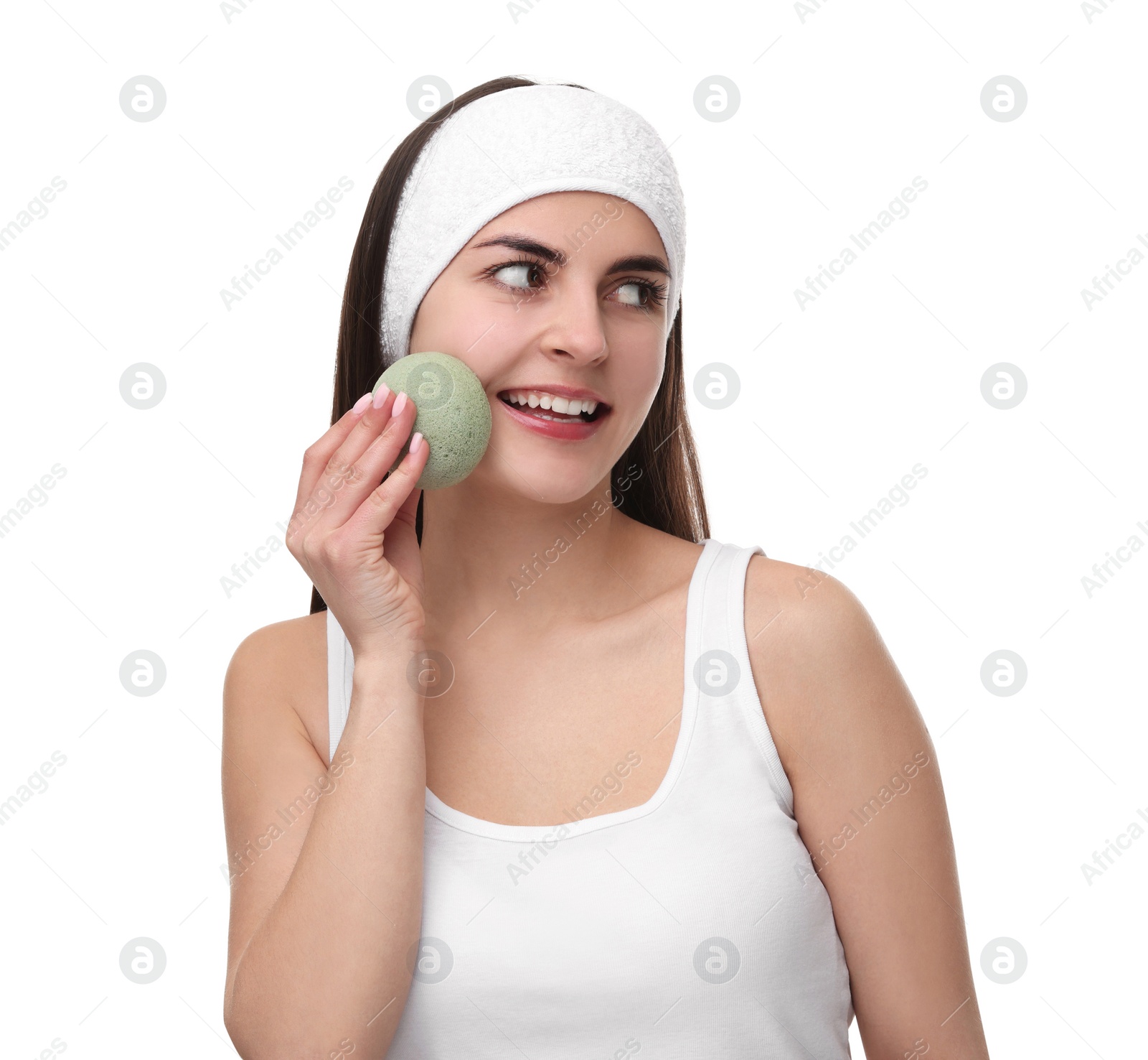 Photo of Young woman with headband washing her face using sponge on white background