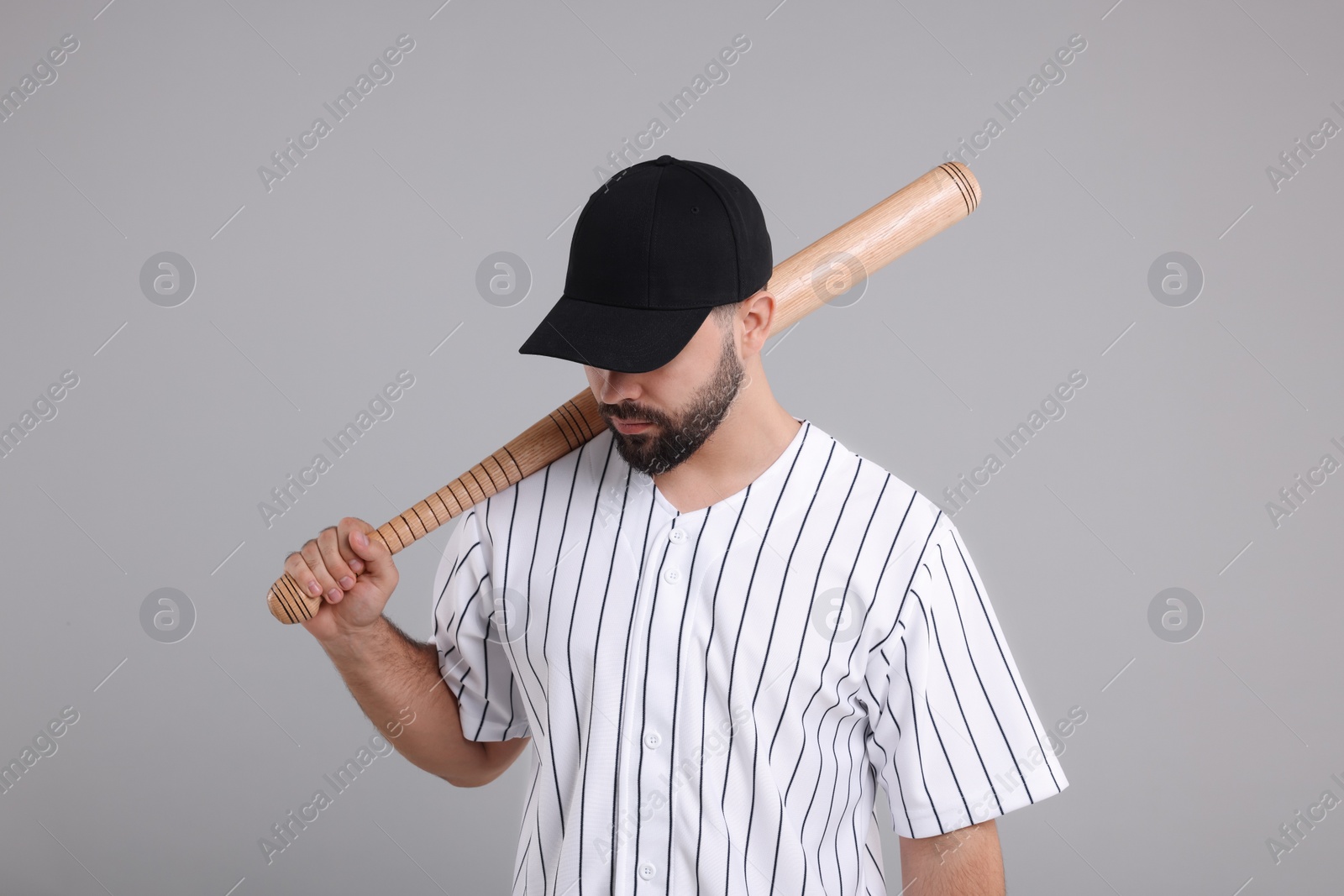 Photo of Man in stylish black baseball cap holding bat on light grey background