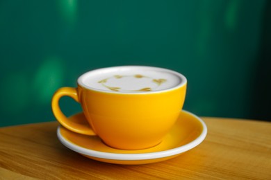 Cup of delicious coffee on wooden table indoors, closeup