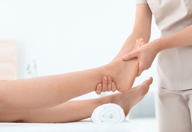 Woman receiving foot massage in wellness center, closeup