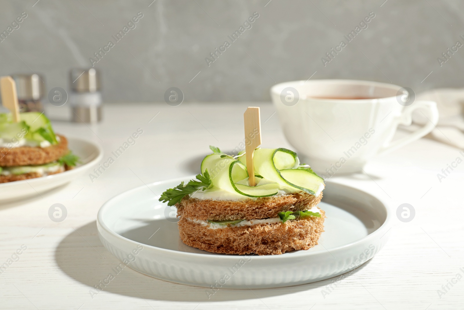 Photo of Plate with traditional English cucumber sandwich on table