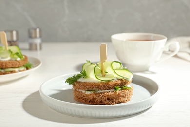 Photo of Plate with traditional English cucumber sandwich on table