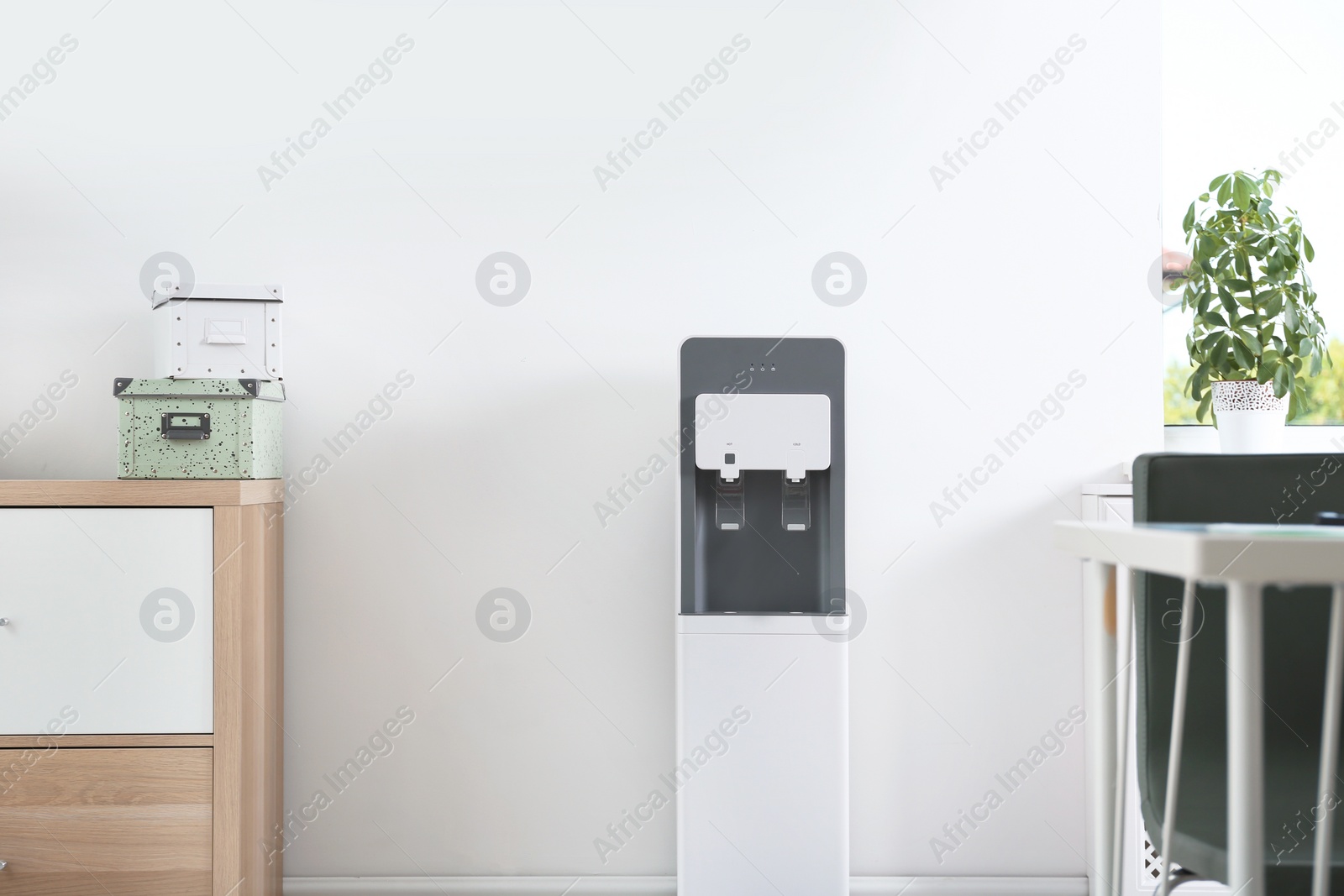 Photo of Modern water cooler in stylish office interior