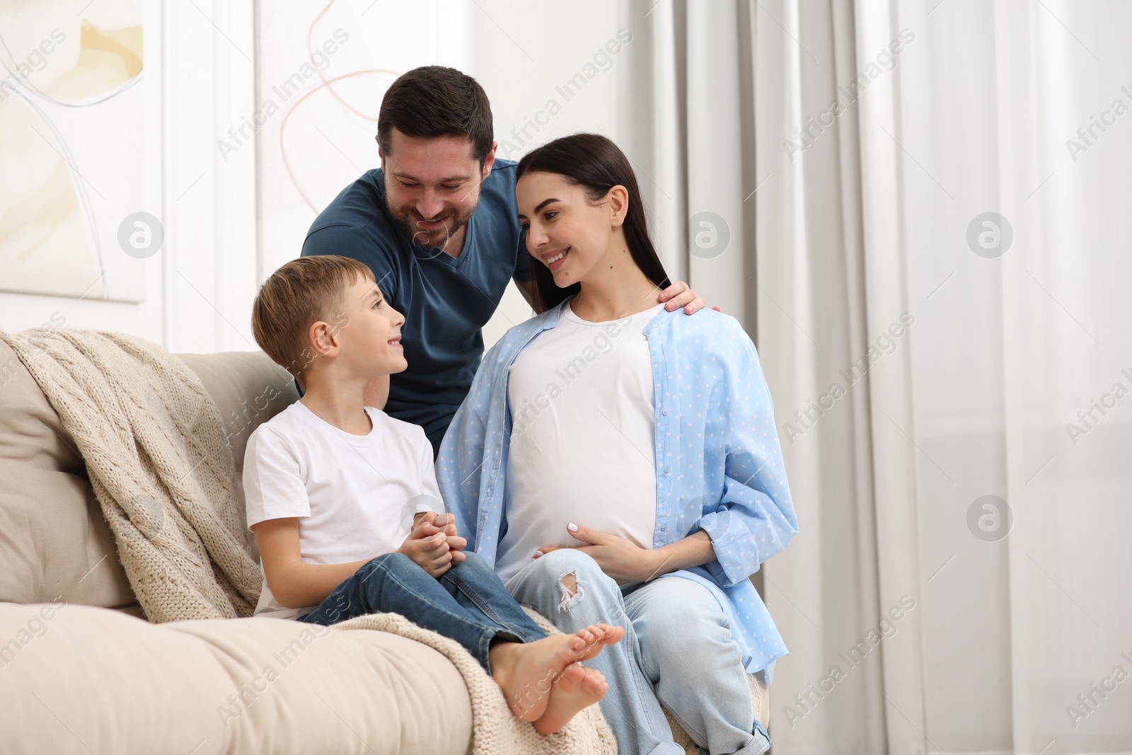 Photo of Pregnant woman spending time with her son and husband at home, space for text. Happy family