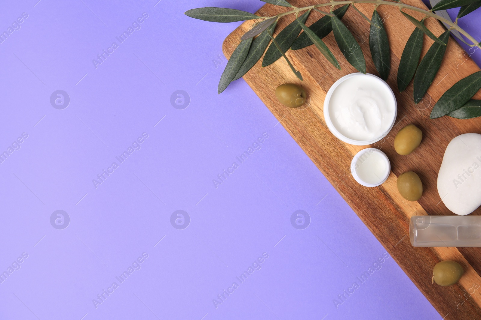 Photo of Different cosmetic products and olives on violet background, top view. Space for text