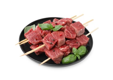 Photo of Wooden skewers with cut fresh beef meat, basil leaves and spices isolated on white