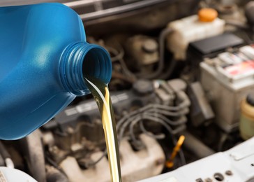 Image of Pouring motor oil from blue container container, closeup