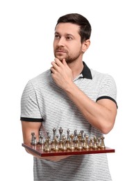 Thoughtful man holding chessboard with game pieces on white background