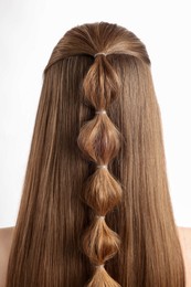 Woman with braided hair on white background, back view