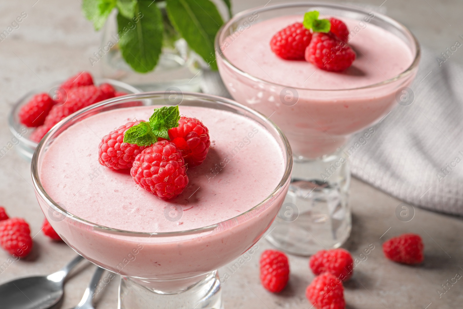 Photo of Delicious raspberry mousse with mint on light grey table