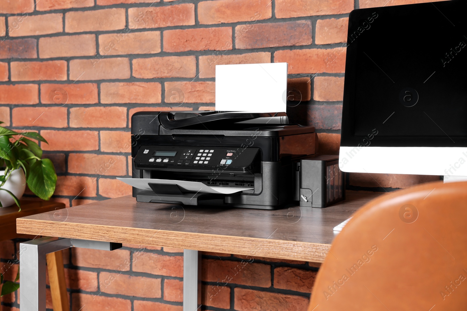 Photo of Stylish workplace with modern computer and printer at home