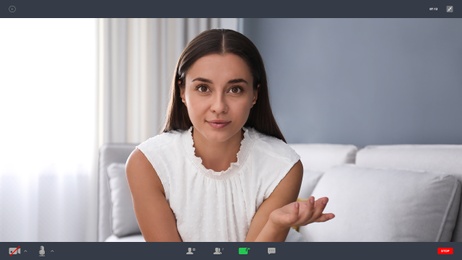 Image of Woman communicating with coworkers from home using video chat, view through camera