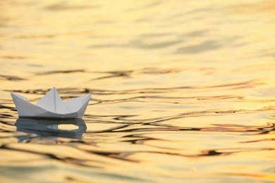 Photo of Paper boat floating on water outdoors. Space for text