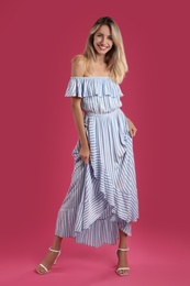 Photo of Young woman wearing stylish dress on pink background