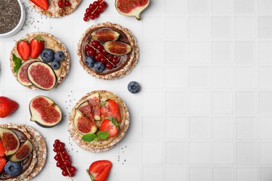 Photo of Flat lay composition with tasty crispbreads, sweet berries and figs on light table. Space for text
