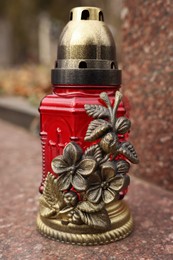 Photo of Grave lantern on granite surface outdoors, closeup