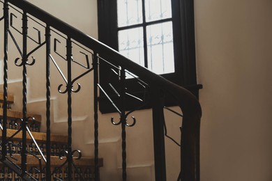 Photo of Stairs and black metal railing indoors. Interior design