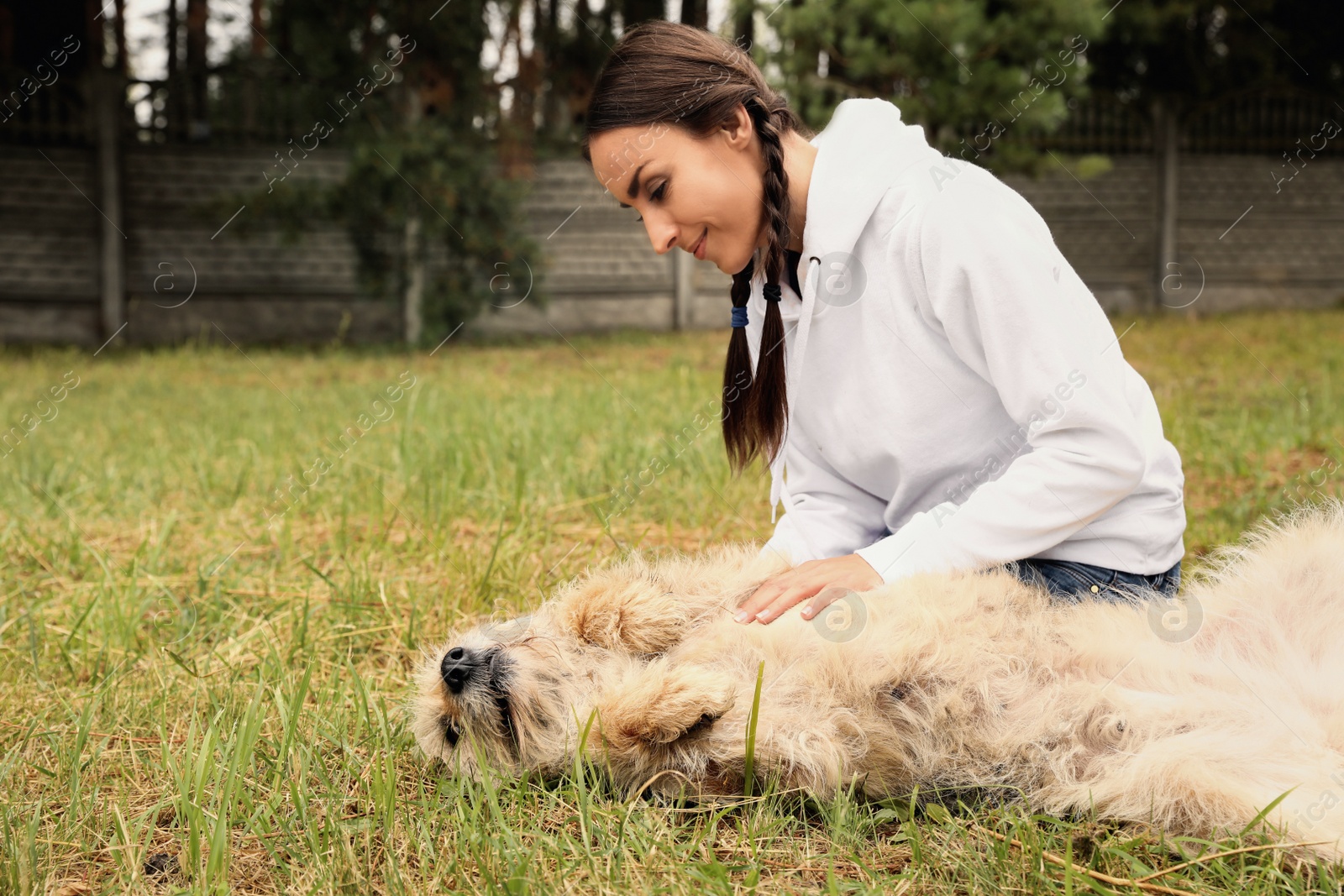 Photo of Female volunteer with homeless dog at animal shelter outdoors