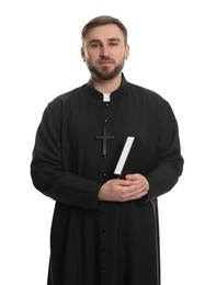 Priest in cassock with Bible on white background