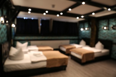 Photo of Blurred view of stylish hotel room interior with comfortable beds