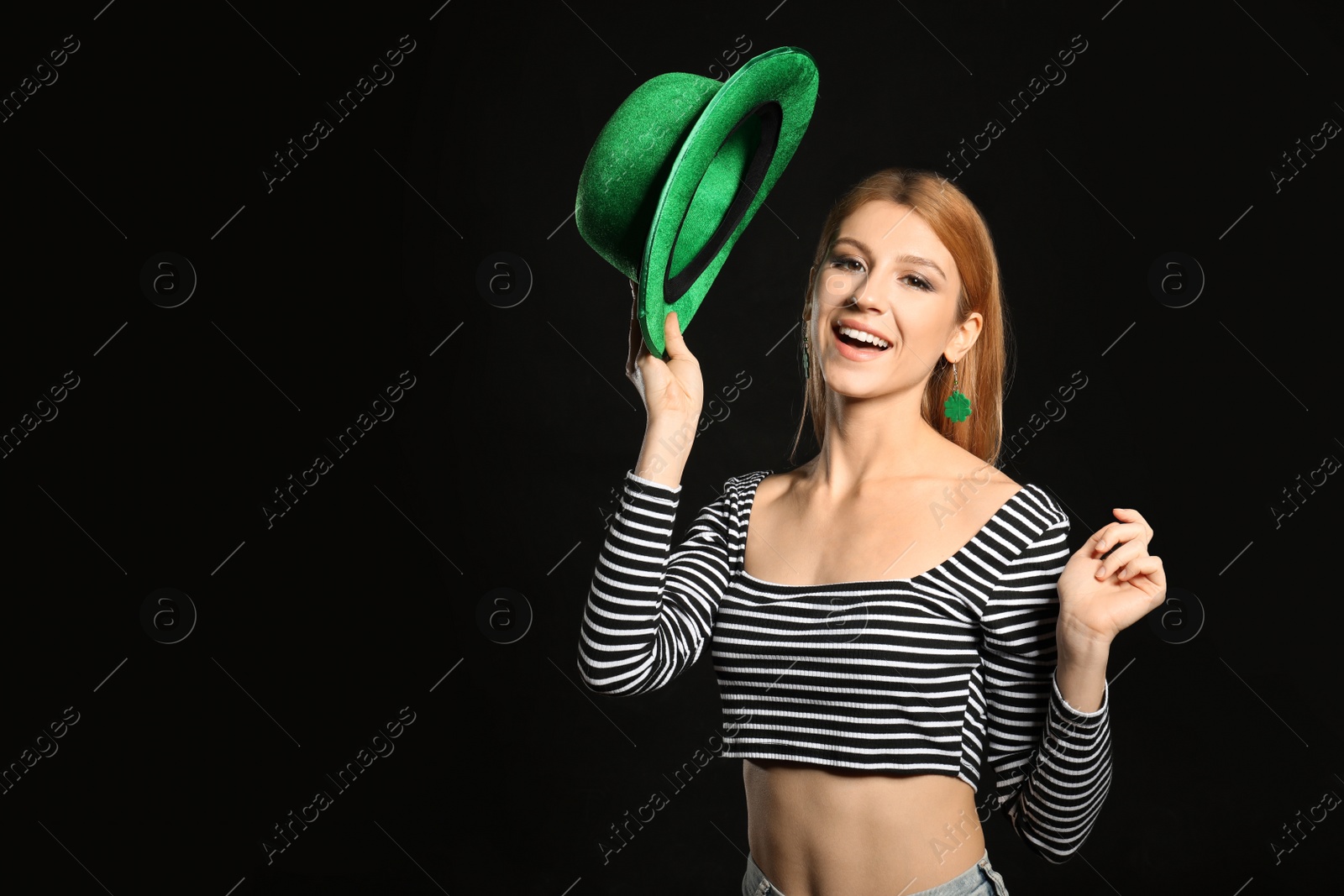 Photo of Young woman with green hat on black background, space for text. St. Patrick's Day celebration