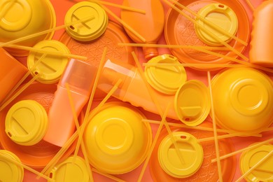 Photo of Different orange plastic items as background, closeup